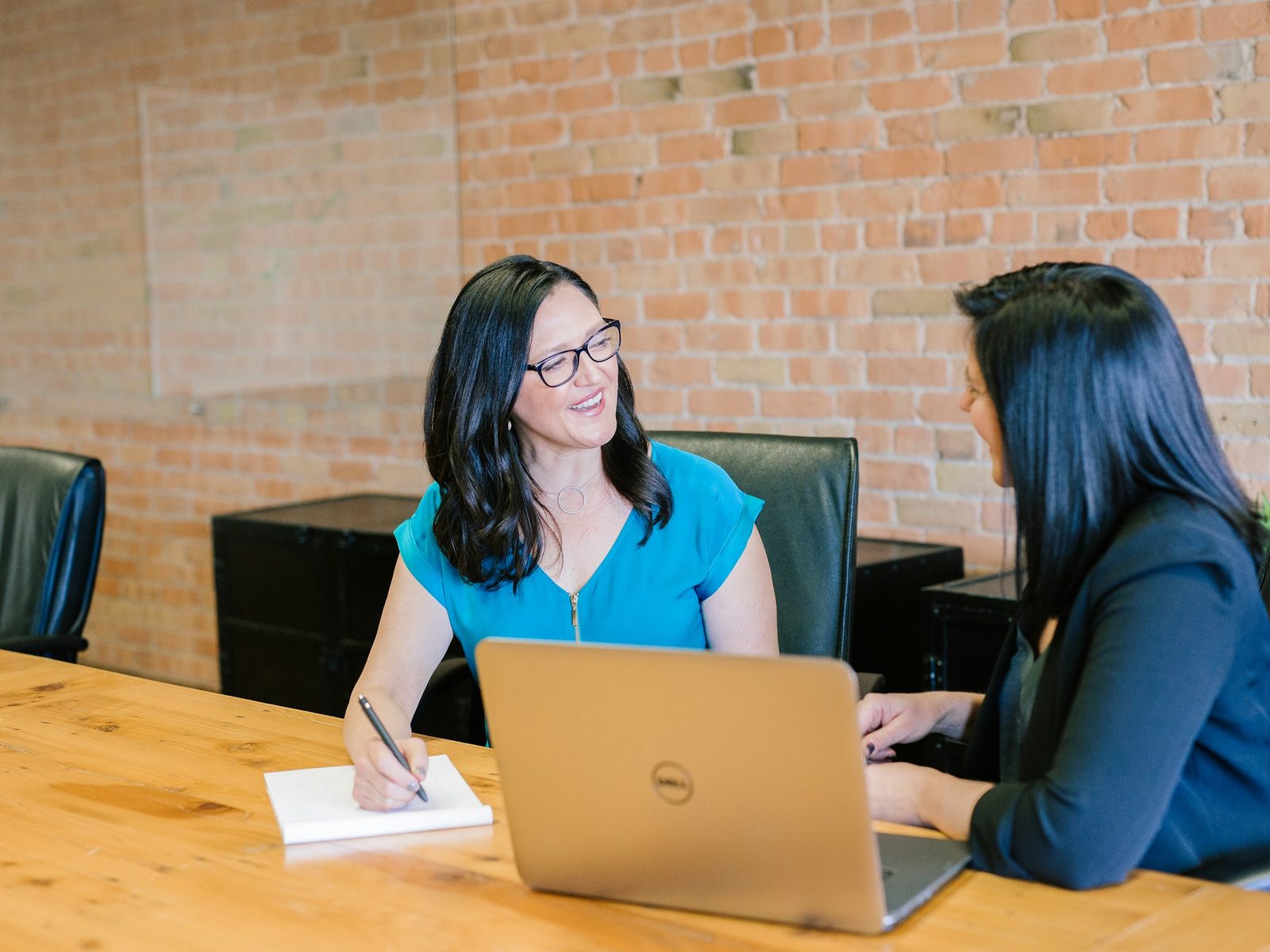 An HR advisor and a client talking through work together at a desk.